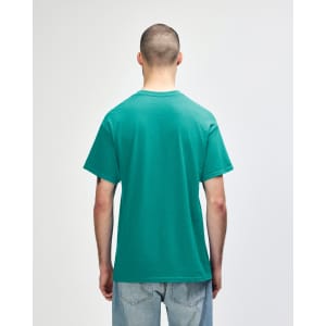 A man wearing a turquoise Gildan Heavy Cotton Adult T-Shirt, viewed from the back. The shirt has a logo.