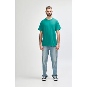 A turquoise Gildan Heavy Cotton Adult T-Shirt displayed on a male model, paired with black jeans and sneakers.