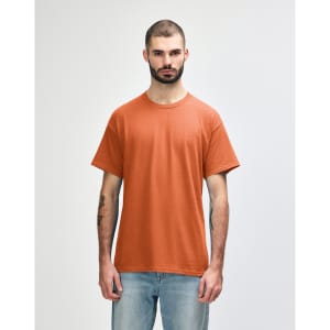 A man wearing a Gildan Heavy Cotton adult T-shirt in a vibrant orange colour, featuring a logo.