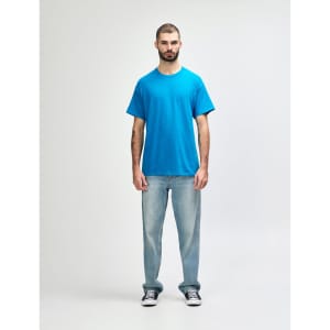A turquoise Gildan Heavy Cotton adult T-shirt displayed on a model wearing black jeans and sneakers.