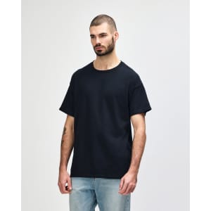 A black Gildan Heavy Cotton Adult T-Shirt displayed on a male model, featuring a simple logo.
