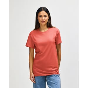 A side view of a man wearing a coral Gildan Heavy Cotton adult t-shirt with short sleeves.