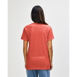 A person wearing a coral Gildan Heavy Cotton Adult T-shirt, viewed from the back, showcasing its simple design.