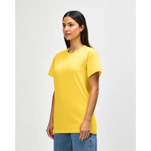 A yellow Gildan Heavy Cotton Adult T-Shirt on a model, featuring a logo. The shirt has a classic fit and short sleeves.