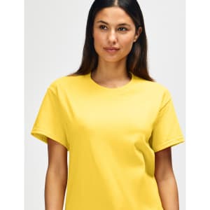 A yellow Gildan Heavy Cotton Adult T-Shirt displayed on a model, featuring a logo.