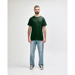 A green Gildan Heavy Cotton adult T-shirt displayed on a male model, paired with black jeans and sneakers.