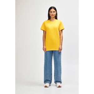 A man wearing a bright yellow Gildan Heavy Cotton T-shirt and black pants, standing with a neutral expression.