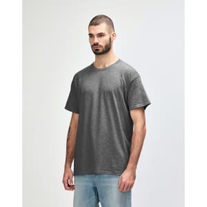 A grey Gildan Heavy Cotton adult t-shirt displayed on a model, featuring a simple design and a logo.