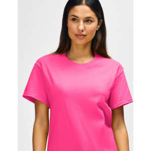 A pink Gildan Heavy Cotton Adult T-Shirt on a model, featuring a plain design and a brand logo.