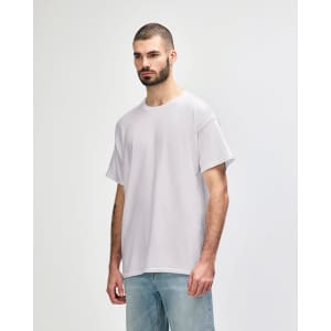 A grey Gildan Heavy Cotton Adult T-Shirt worn by a model, featuring a simple design and relaxed fit.