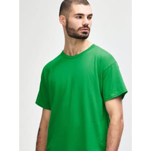A green Gildan Heavy Cotton adult T-shirt displayed on a model. The shirt has a simple design and no visible logos.