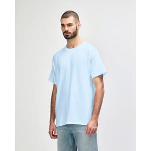 A light blue Gildan Heavy Cotton adult t-shirt is displayed on a model. It features short sleeves and a simple design.
