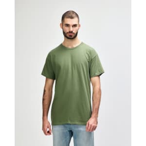 A green Gildan Heavy Cotton adult t-shirt worn by a model standing against a plain background.