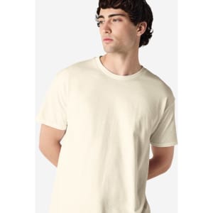 A cream-coloured Gildan Heavy Cotton adult T-shirt, displayed on a model with short curly hair.