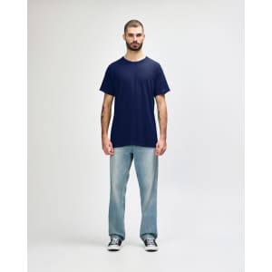 A navy Gildan Heavy Cotton adult T-shirt displayed on a model wearing black jeans and sneakers, with a logo present.