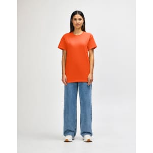 An orange Gildan Heavy Cotton Adult T-Shirt displayed on a male model, paired with black jeans and shoes.