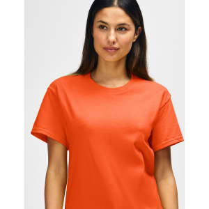An orange Gildan Heavy Cotton Adult T-Shirt displayed on a model, featuring a simple design and logo.
