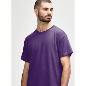 A purple Gildan Heavy Cotton adult t-shirt, displayed on a model with hands behind their back.