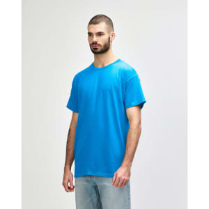 A model wearing a bright blue Gildan Heavy Cotton adult T-shirt, featuring a plain design and a logo on the chest.