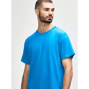 A plain turquoise adult t-shirt displayed on a model, featuring a simple design and a crew neck.
