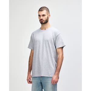 A grey Gildan Heavy Cotton adult T-shirt displayed on a model, featuring a simple design and a relaxed fit.