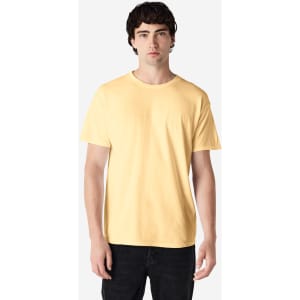 A model wearing a yellow Gildan Heavy Cotton adult T-shirt, paired with blue jeans. The shirt has a logo.