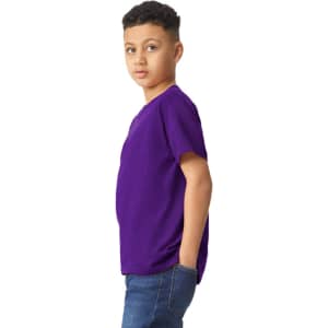 A young model wearing a purple Gildan Heavy Cotton Youth T-Shirt, posing sideways with hands in pockets.