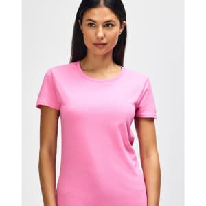A pink Gildan Heavy Cotton Ladies' T-Shirt displayed on a smiling woman, featuring a simple design and a logo.
