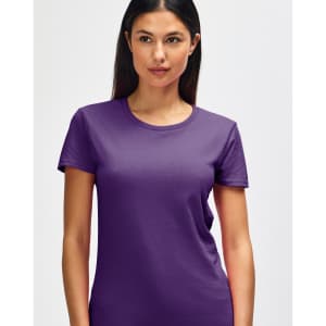 A purple Gildan Heavy Cotton Ladies' T-Shirt displayed on a smiling woman, featuring a round neck and short sleeves.