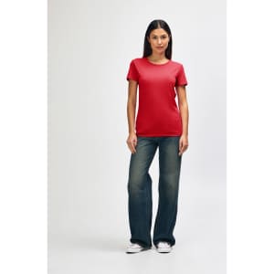 A red Gildan Heavy Cotton Ladies' T-Shirt displayed on a model wearing blue jeans and white sneakers, with a logo present.