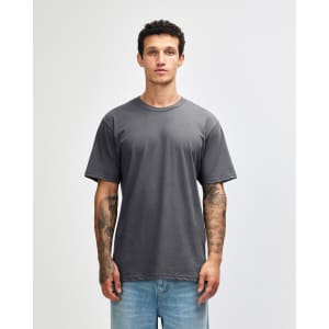 A grey unisex short sleeve T-shirt displayed on a model with tattoos, featuring a simple design and relaxed fit.
