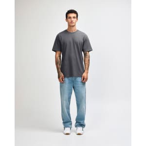 A grey unisex short sleeve t-shirt displayed on a model wearing light blue jeans and white shoes.