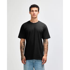 A black unisex short sleeve t-shirt on a model with tattoos, featuring a simple design and relaxed fit.