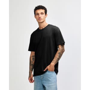 A black sueded unisex short sleeve T-shirt displayed on a model with tattoos, paired with light blue jeans.
