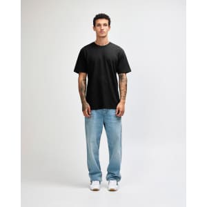 A black unisex short sleeve T-shirt displayed on a model wearing light blue jeans and sneakers.