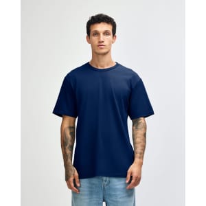 A navy unisex short sleeve T-shirt displayed on a model with tattoos, featuring a simple design and no visible branding.
