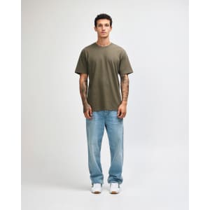 A model wearing an olive green unisex short sleeve T-shirt paired with black cargo pants and sneakers.