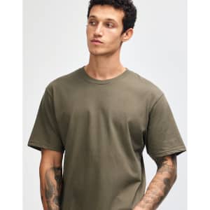 A model wearing an olive green unisex short sleeve t-shirt, featuring a logo on the shirt.