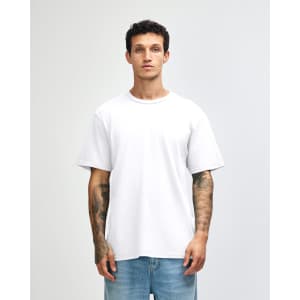 A white unisex short sleeve t-shirt displayed on a model, featuring a simple design and casual fit.