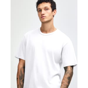 A white unisex short sleeve T-shirt on a model with tattoos, featuring a simple design and a logo.