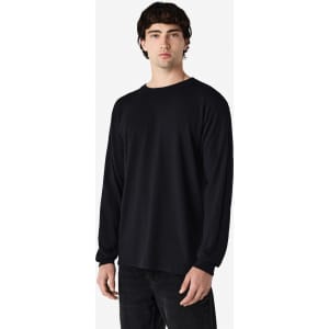 A model wearing a black Gildan Heavy Cotton adult long sleeve T-shirt. The shirt features a simple design and a logo.