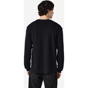 A man is wearing a black long sleeve t-shirt, viewed from the back. The shirt has a logo on it.