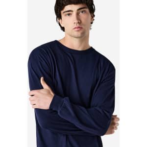 A model wearing a navy long sleeve T-shirt with a relaxed fit and a logo on the sleeve.