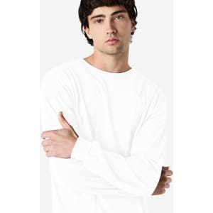 A white long sleeve T-shirt on a model with a neutral background, featuring a logo on the sleeve.