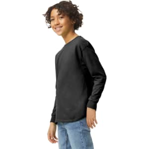 A youth long sleeve t-shirt in black, featuring a logo, worn by a smiling child.
