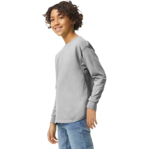 A youth long sleeve T-shirt in grey, featuring a logo, displayed on a model smiling at the camera.