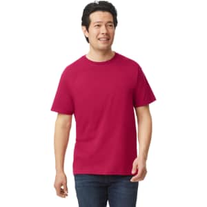 A man wearing a maroon Gildan Softstyle adult T-shirt stands and smiles. The shirt has a logo on it.