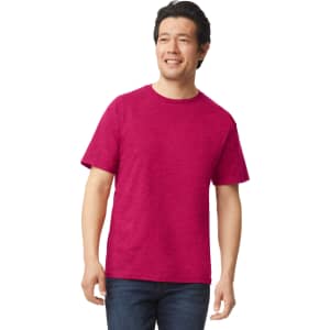 A man wearing a bright pink Gildan Softstyle adult T-shirt, paired with dark jeans. The shirt has a logo.