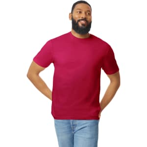 A man wearing a burgundy Gildan Softstyle adult T-shirt paired with blue jeans, smiling. The shirt features a logo.