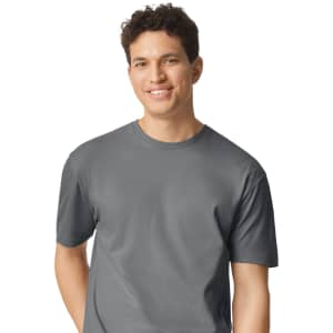 A grey Gildan Softstyle adult t-shirt displayed on a smiling male model, with a simple logo on the shirt.